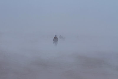 Photograph of a person walking out of the fog.